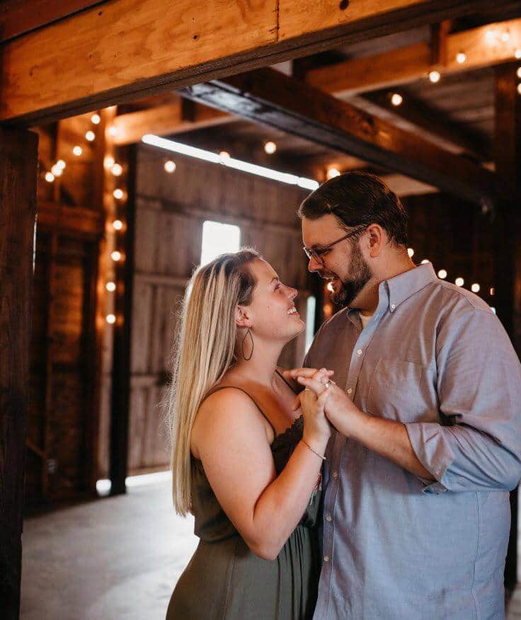 Lori and Chad, the owner/operators of the Manor at Stowers Hill in East Tennessee, holding hands and smiling at each other. 